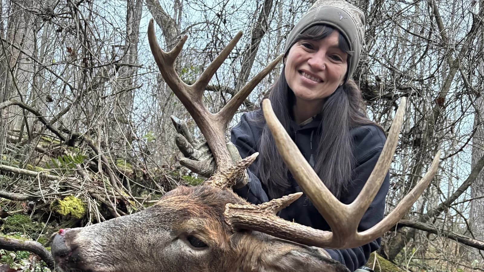 Stacey Horbatak, owner of Holy Ground Outdoors, with her whitetail buck.