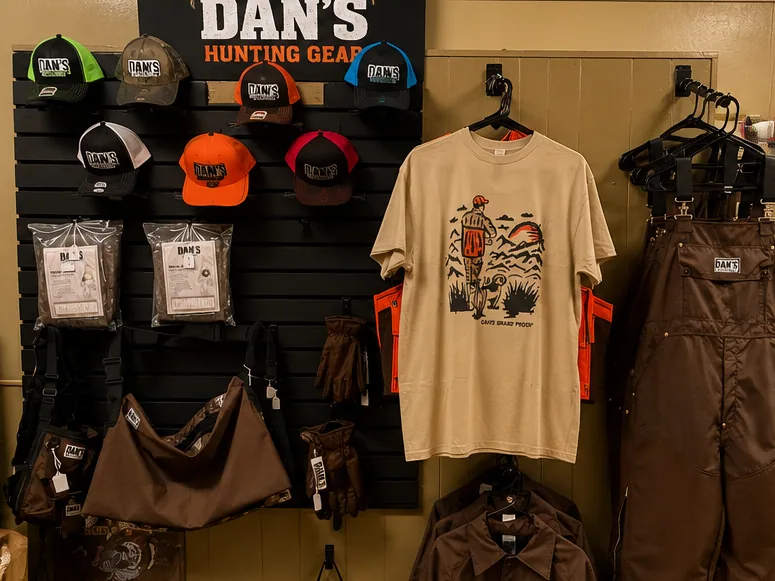 Dan's Hunting Gear apparel wall — caps, tees, jackets, and bibs