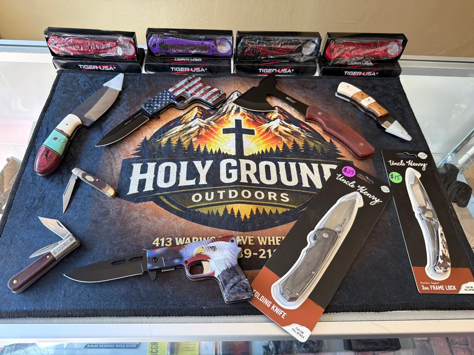 Folding knives, fixed blades, and tomahawks on a Holy Ground Outdoors mat
