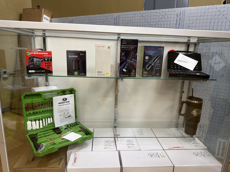 Glass case of optics, flashlights, and gun-cleaning kits at Holy Ground Outdoors